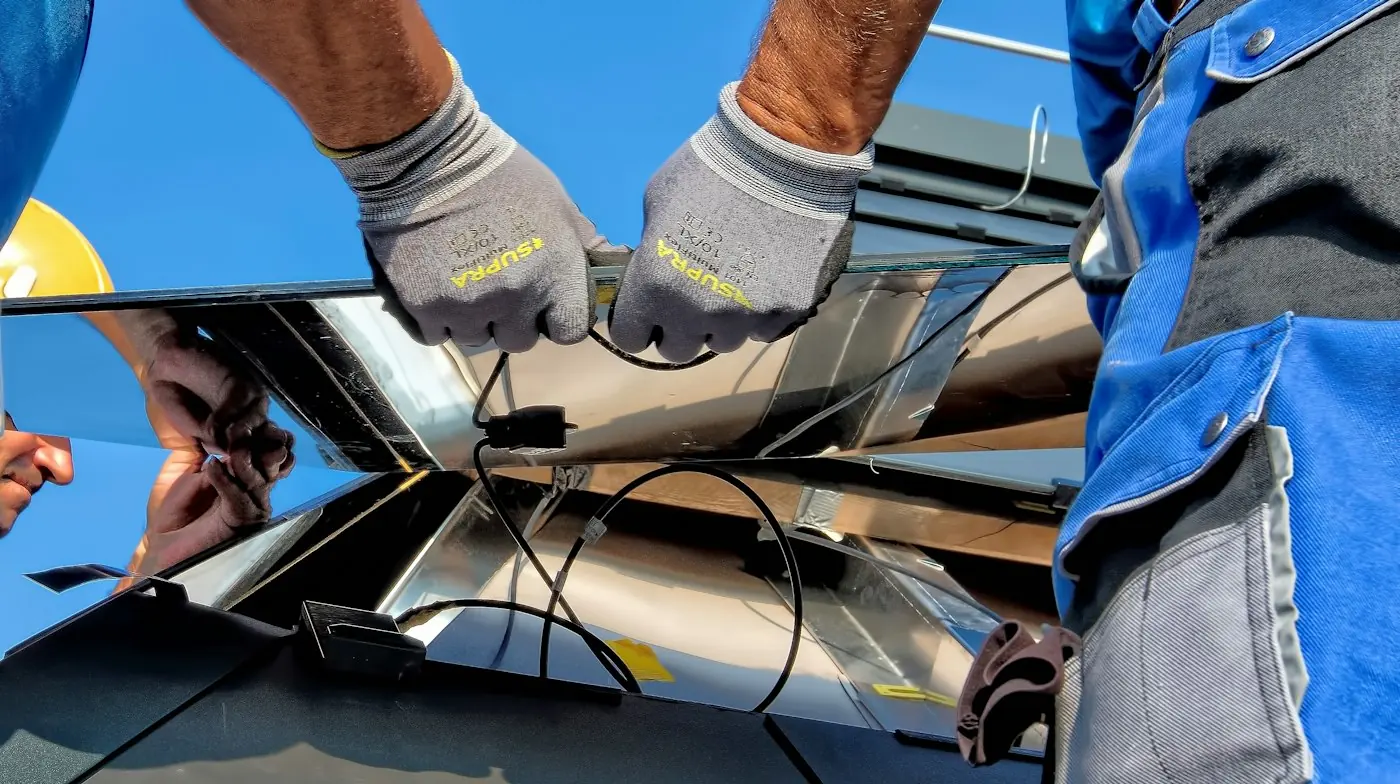 Técnico conectando cableado de un sistema solar con guantes de trabajo